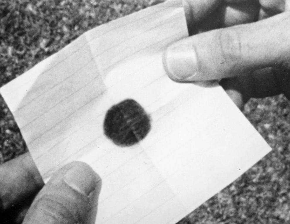Image of a piece of paper with a black dot on it. 